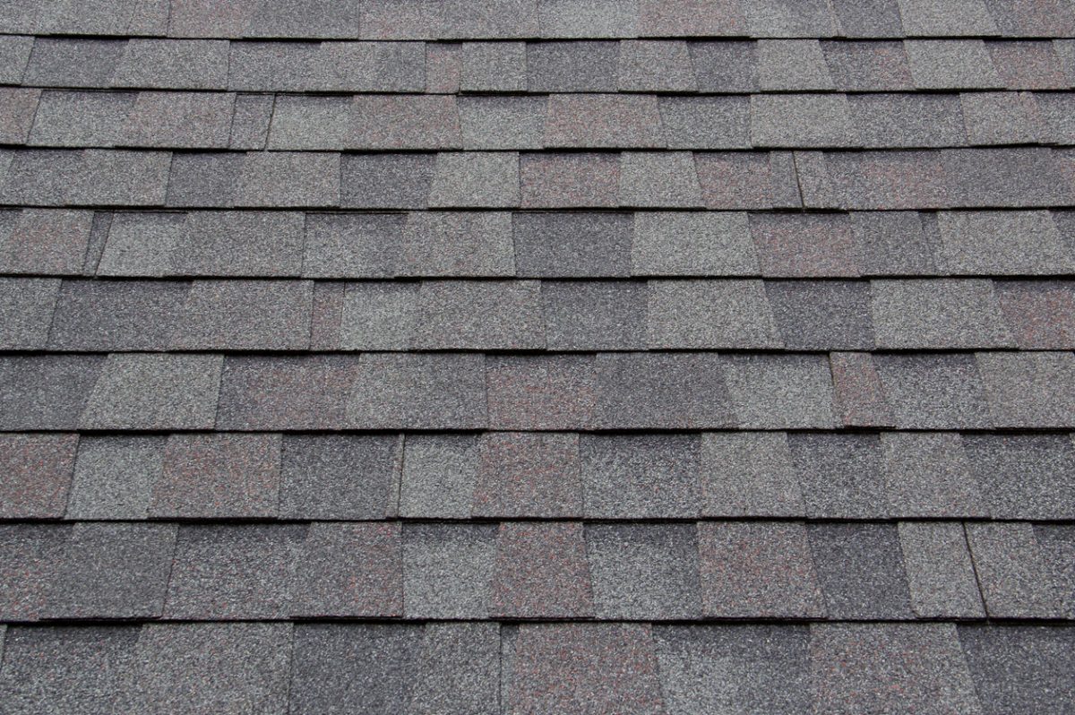 dark new roof shingle background and texture. asphalt tiles of house roof.