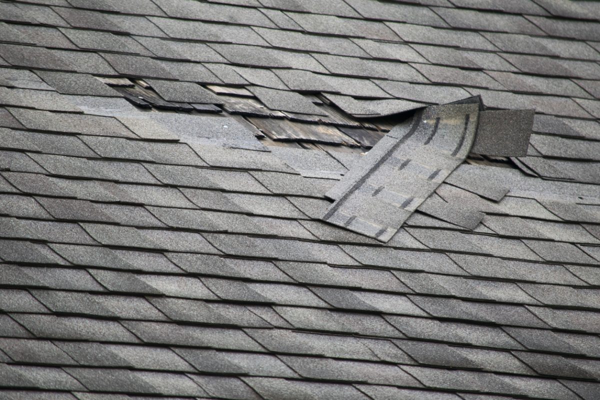 A badly damaged roof with missing shingles in need of repair