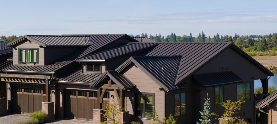 This image shows how attractive brown metal roofing blends with modern residential architecture. Afternoon side lighting accentuates the pleasing lines of the roofing seams.