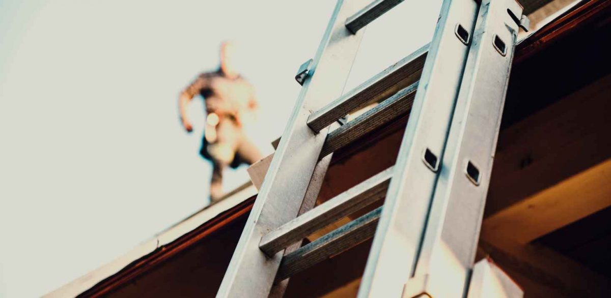 Closeup of a ladder on a roof, roofing safety tips