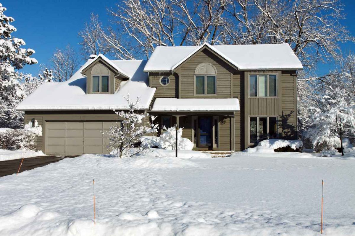 Common winter roofing issues; Suburban colonial house in winter snow